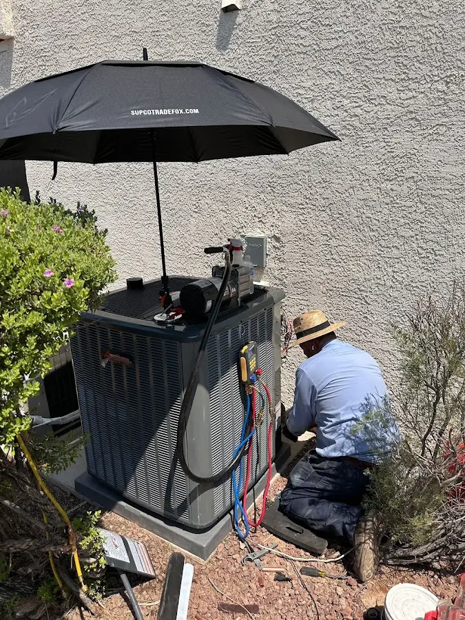 HVAC technician performing outdoor AC maintenance in Hobe Sound