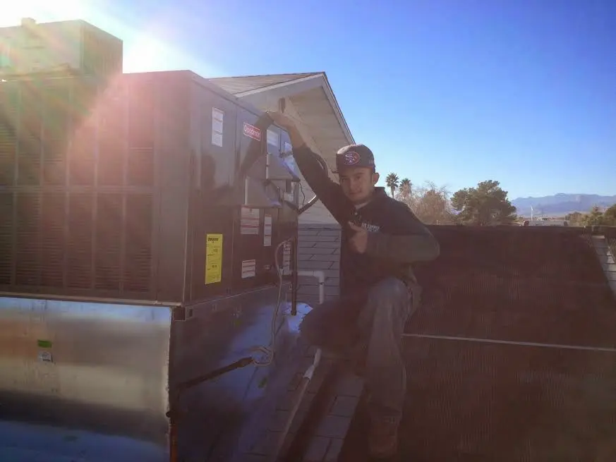 HVAC technician performing AC Tune-Up on a rooftop unit in Hobe Sound